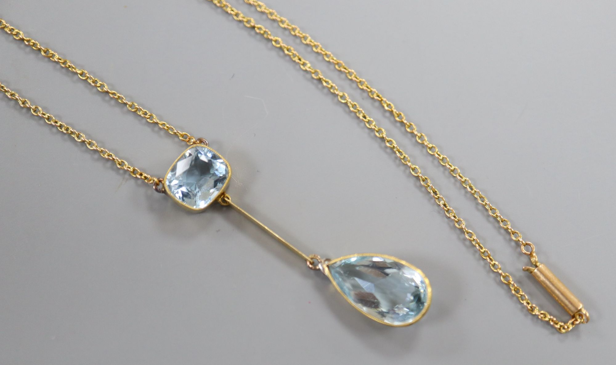 A yellow metal and two stone aquamarine drop pendant necklace, 25.5cm, gross 5.8 grams.